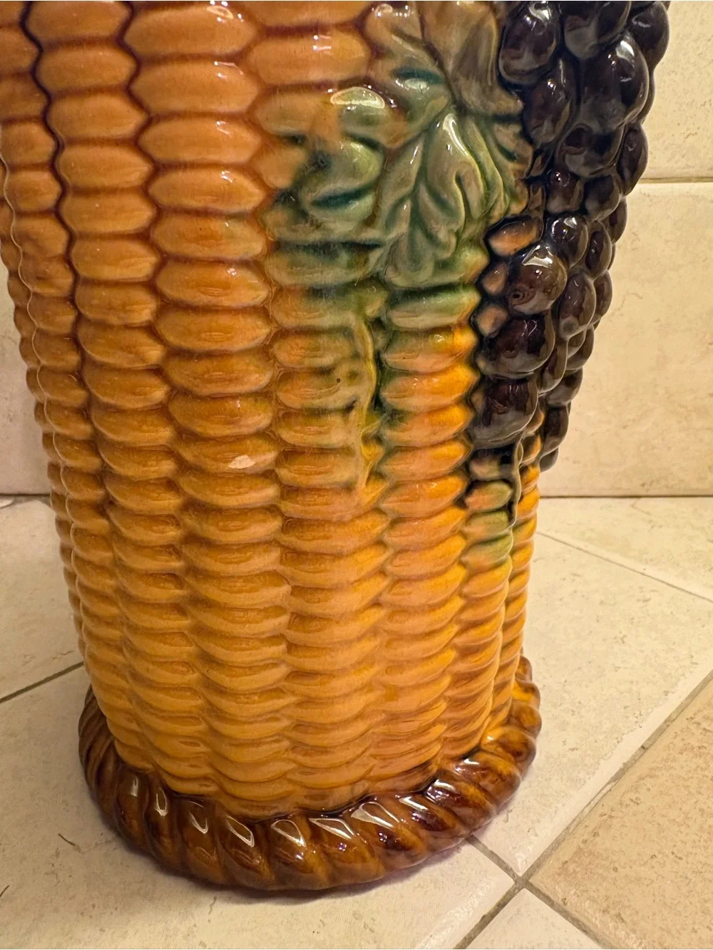 Majolica style ceramic vase featuring an embossed grape and basket weave motif.
